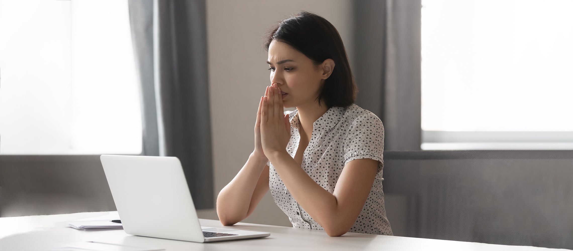 worried woman looking at laptop