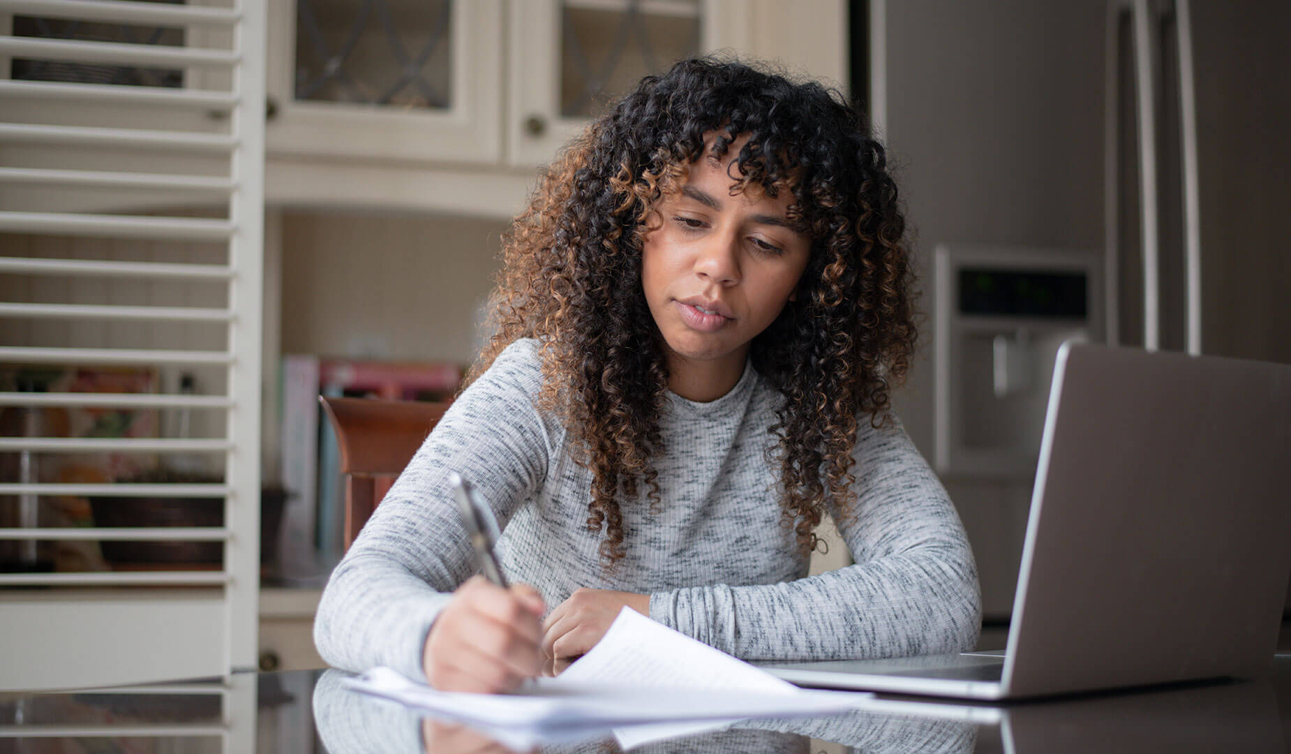 woman writing on papers at a desk