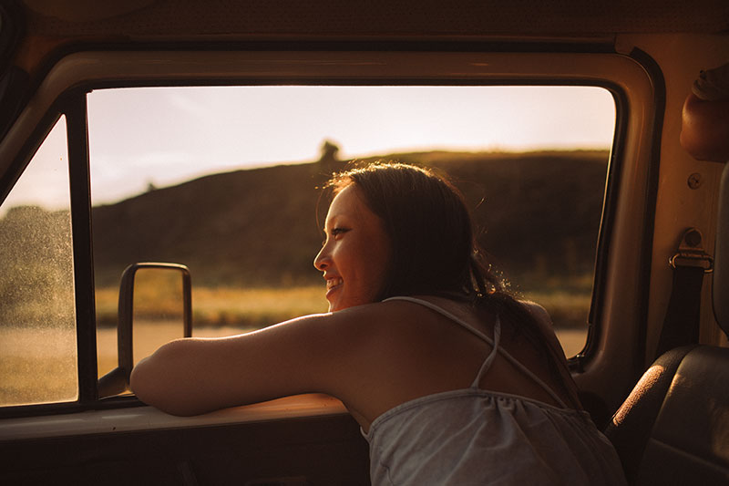 girl in car with head out of the window