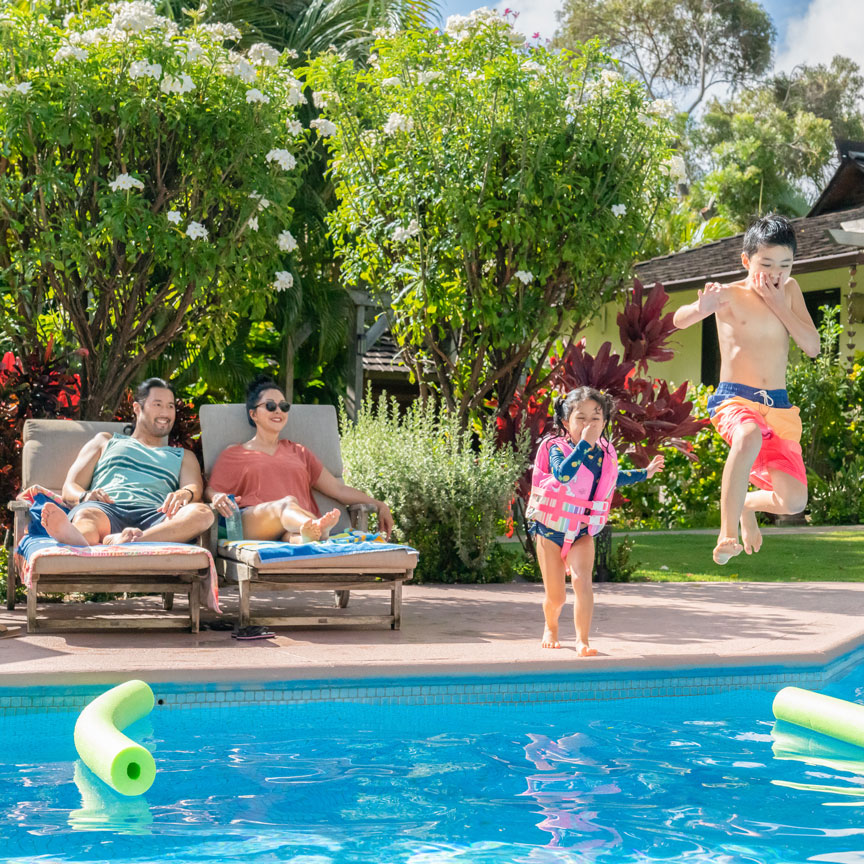 parents watching children jump into a pool