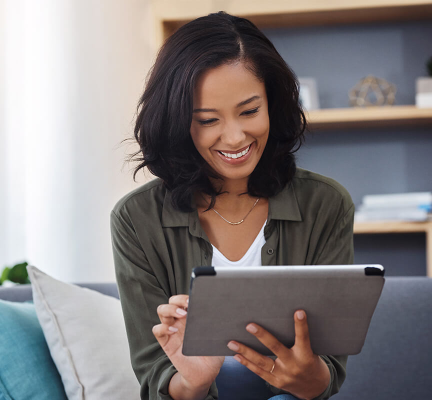 woman sitting on couch with tablet